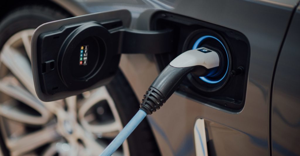 an electric car's charging port with charger plugged in